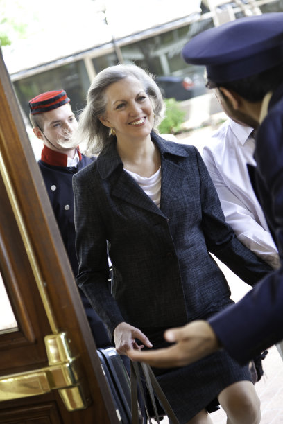 酒店门卫在门口迎接一位资深女士图片下载