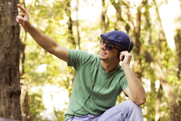 微笑随意的家伙在手机上听音乐图片下载