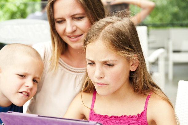 母亲和两个孩子使用平板电脑图片下载
