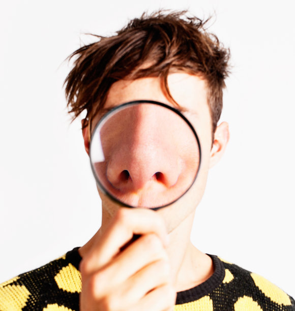 放大镜戏剧性地放大了这个年轻人的鼻子图片下载