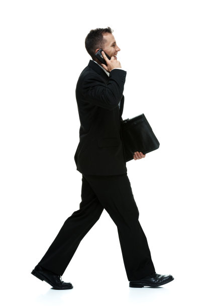 微笑的商人用手机和走路聊天图片下载