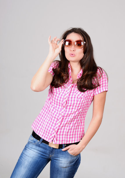 可爱的白人年轻女子在格子衬衫与太阳镜摆姿势图片下载