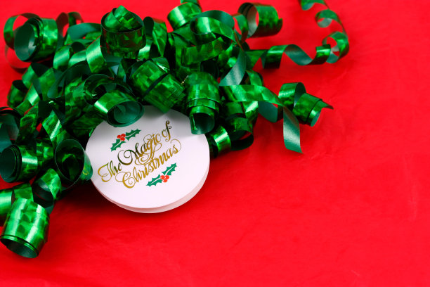 红色背景墙纸上的圣诞礼物蝴蝶结和名牌图片下载