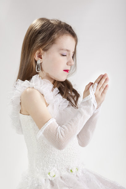 金发小公主穿着白裙子祈祷图片下载