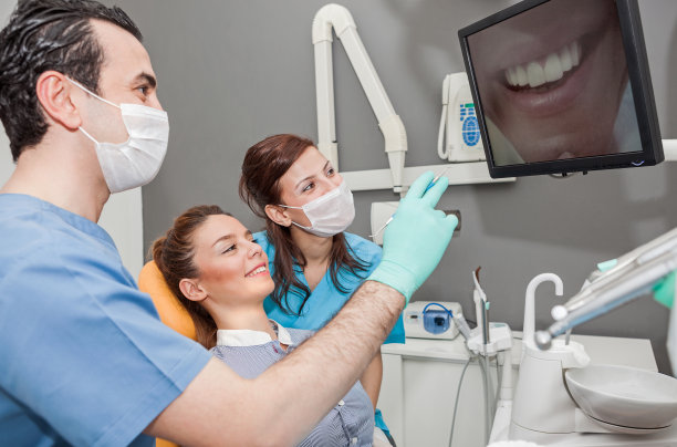 牙医和女病人在看监视器上的牙齿图片图片下载