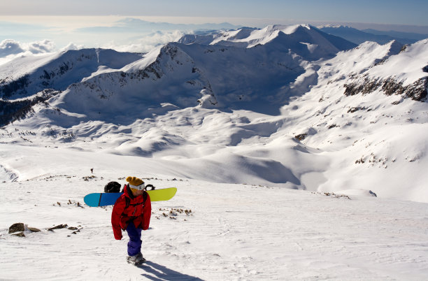 年轻的滑雪板运动员在爬山图片下载