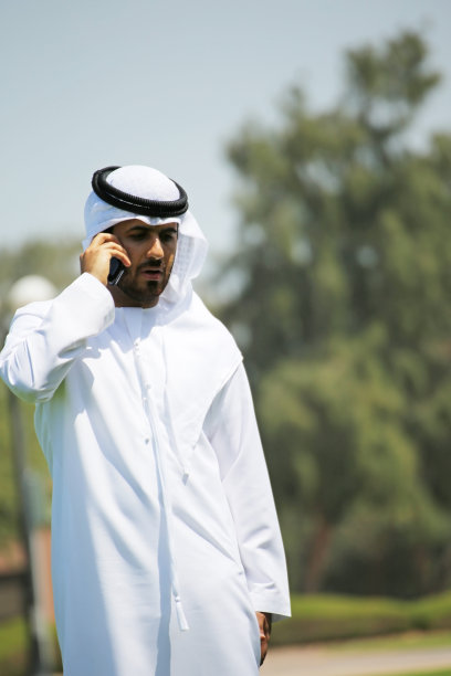 在公园里用手机交谈的阿拉伯男子图片下载