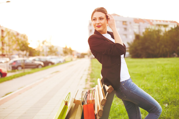 微笑的女孩与购物袋。图片下载