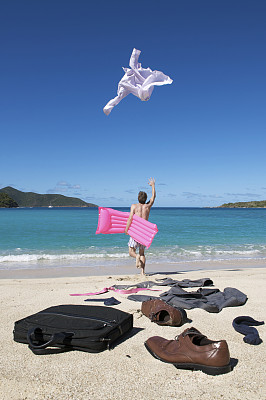 无忧无虑的商人跑去度假扔西装在海滩上图片下载