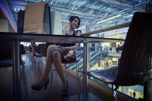 在咖啡馆打电话的购物袋女人图片下载