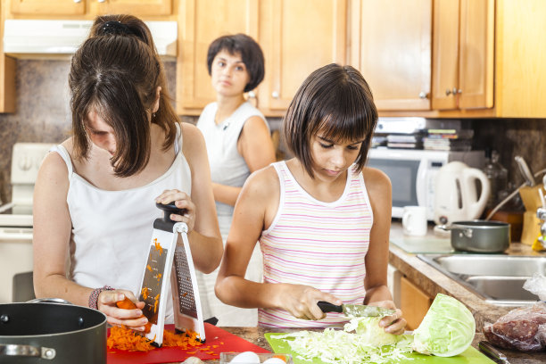 家庭，母亲和两个女儿，做沙拉图片下载