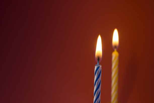 在copyspace的红色背景上点燃生日蜡烛图片下载