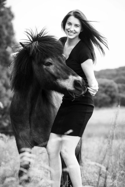 年轻迷人的女人在喂她的岛屿小马图片下载