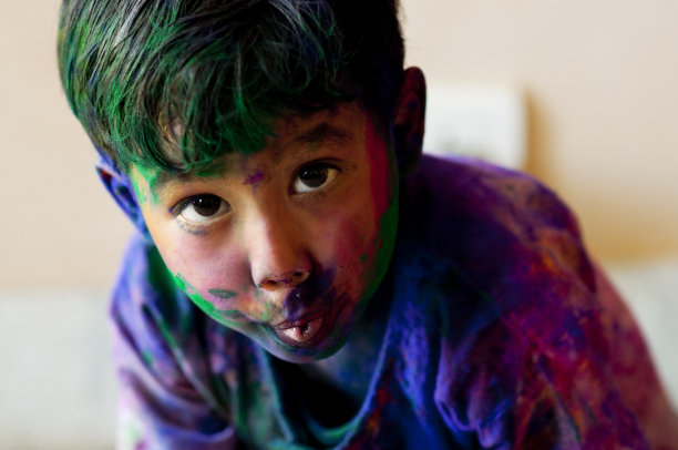 调皮的小男孩涂抹胡里节的颜色图片下载