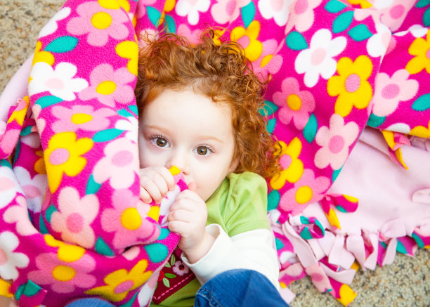 藏在毯子里吮拇指的女孩图片下载