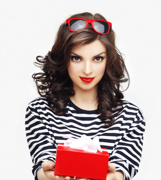 微笑的女孩穿着条纹上衣，手里拿着礼盒图片下载