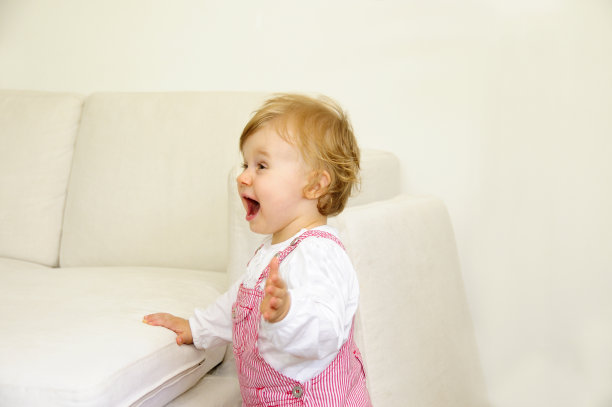 可爱的小女孩兴奋有趣站着大喊看沙发图片下载