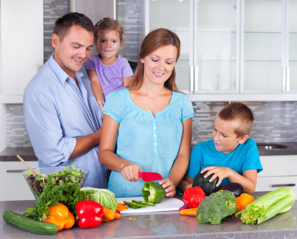 年轻的家庭在厨房里一起做晚餐图片下载