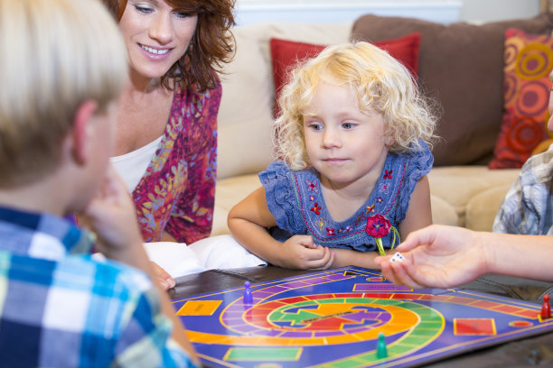 一家人在家里玩令人兴奋的棋盘游戏图片下载