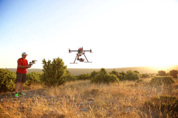 日落时分，有人在驾驶无人机图片下载