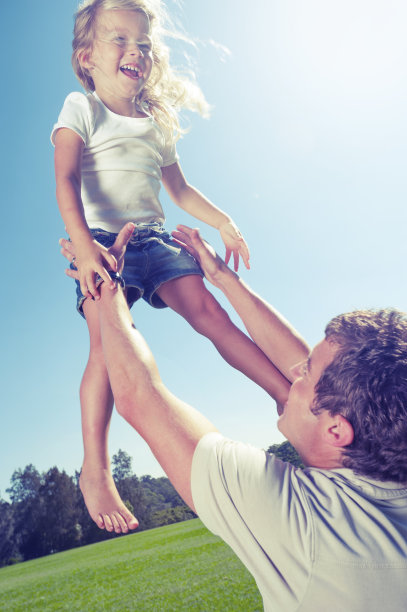 男人把女儿举到空中。图片下载