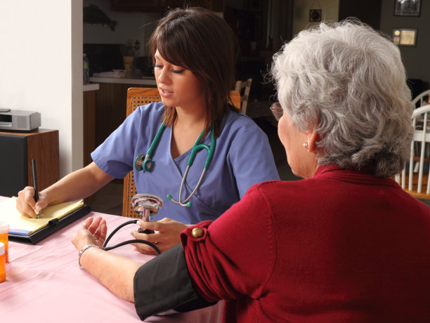 辅助生活护士检查老人的血压图片下载