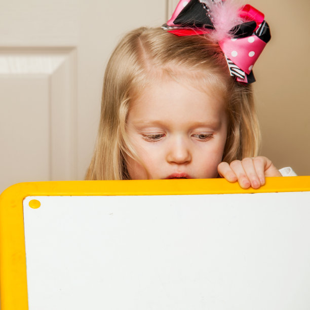 3岁的小女孩在空白的表面下窥视图片下载