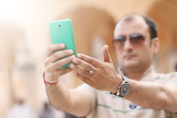 中年男子用智能手机自拍图片下载