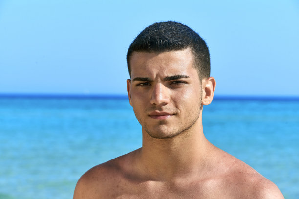 男孩在海滩上看相机图片下载