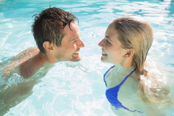 幸福的一对在游泳池里看着对方图片下载