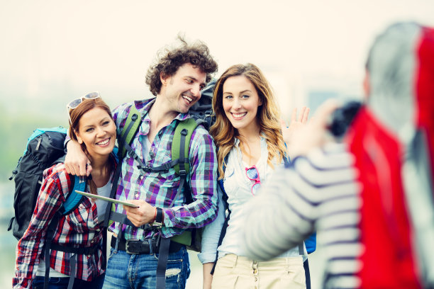 快乐的背包客在城市里拍照。图片下载