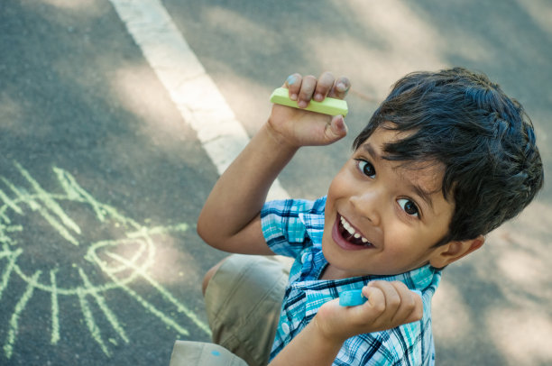 快乐的小男孩用粉笔画画图片下载