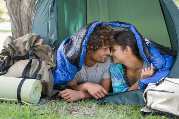 一对年轻夫妇在睡袋里互相微笑图片下载