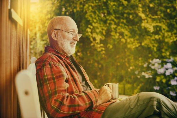 一位退休老人边喝着咖啡边欣赏他的花园图片下载