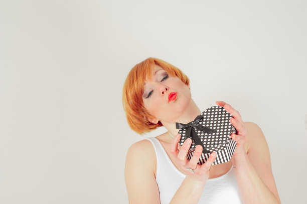 美丽的年轻女人拿着情人节礼物盒图片下载