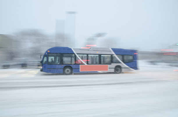 在暴风雪期间在公路上的公共汽车上平移图片下载