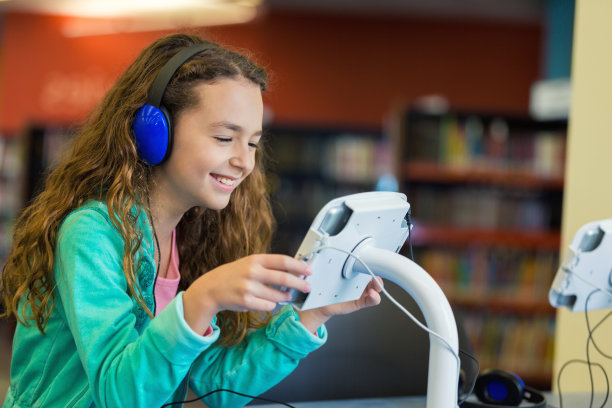 可爱的小学生在小学图书馆使用平板电脑图片下载