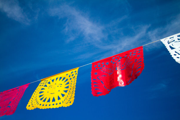 明亮的墨西哥节日旗帜在蓝天下飘扬图片下载