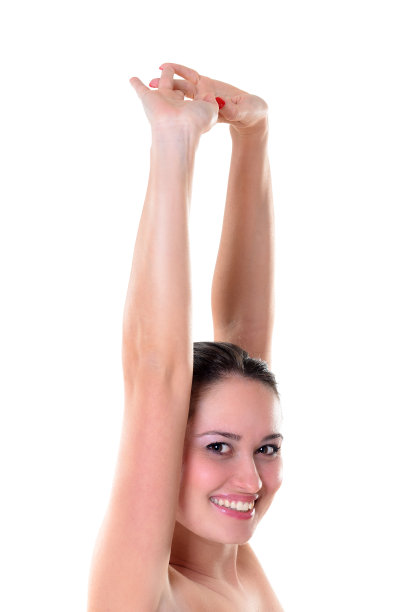 健康的年轻女子伸展在白色的背景和微笑图片下载