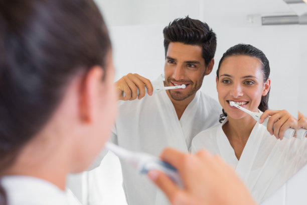 一对夫妇在浴室镜子前刷牙图片下载