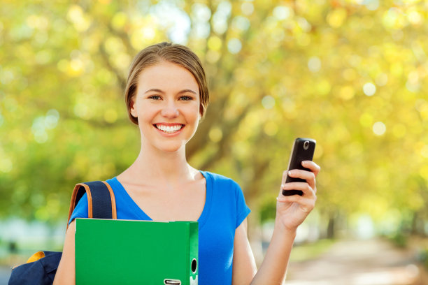 快乐的学生与戒指夹和智能手机在校园图片下载