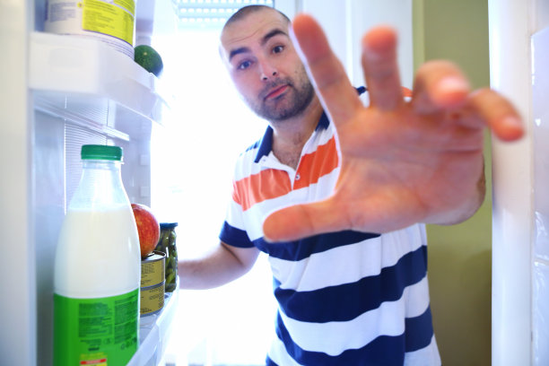 从冰箱里拿食物的家伙。图片下载