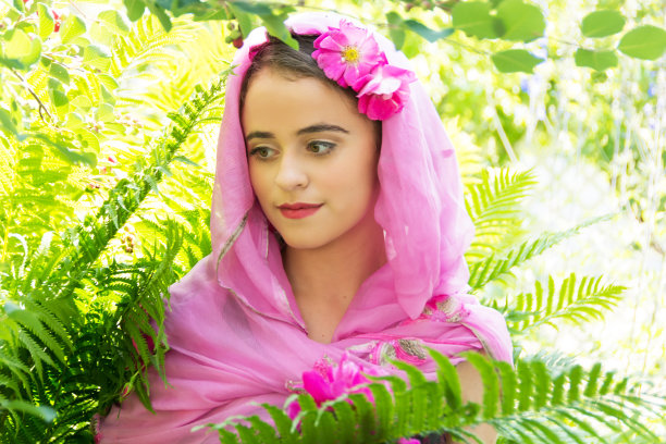 严肃的15岁，戴着粉色围巾，在明亮的花园里图片下载