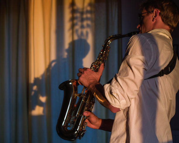 萨克斯管手在室内演奏他的乐器图片下载