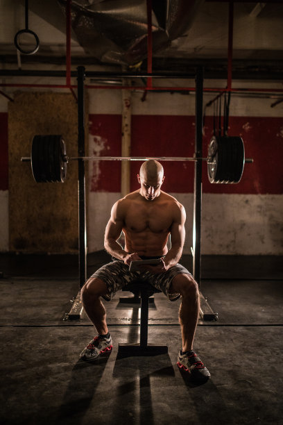 肌肉男在健身房使用平板电脑图片下载