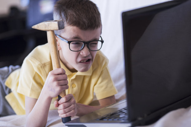 这个男孩想用锤子砸碎一台笔记本电脑图片下载