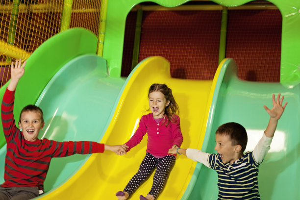 孩子们在室内游乐场滑滑梯图片下载