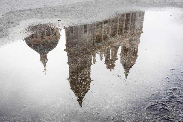 西班牙马德里，阿慕德娜大教堂在街道水坑上的倒影。图片下载