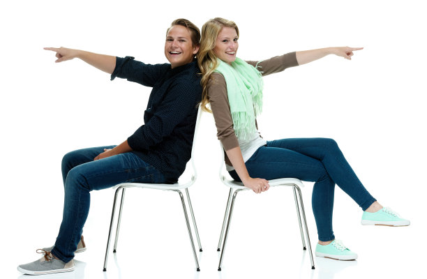 幸福的一对坐在椅子上，指着图片下载