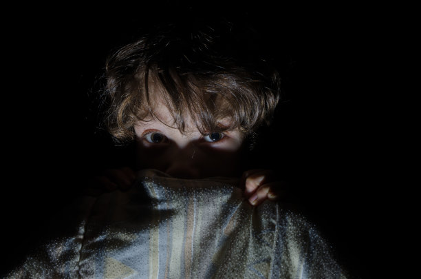 小男孩害怕躲在床单后面图片下载